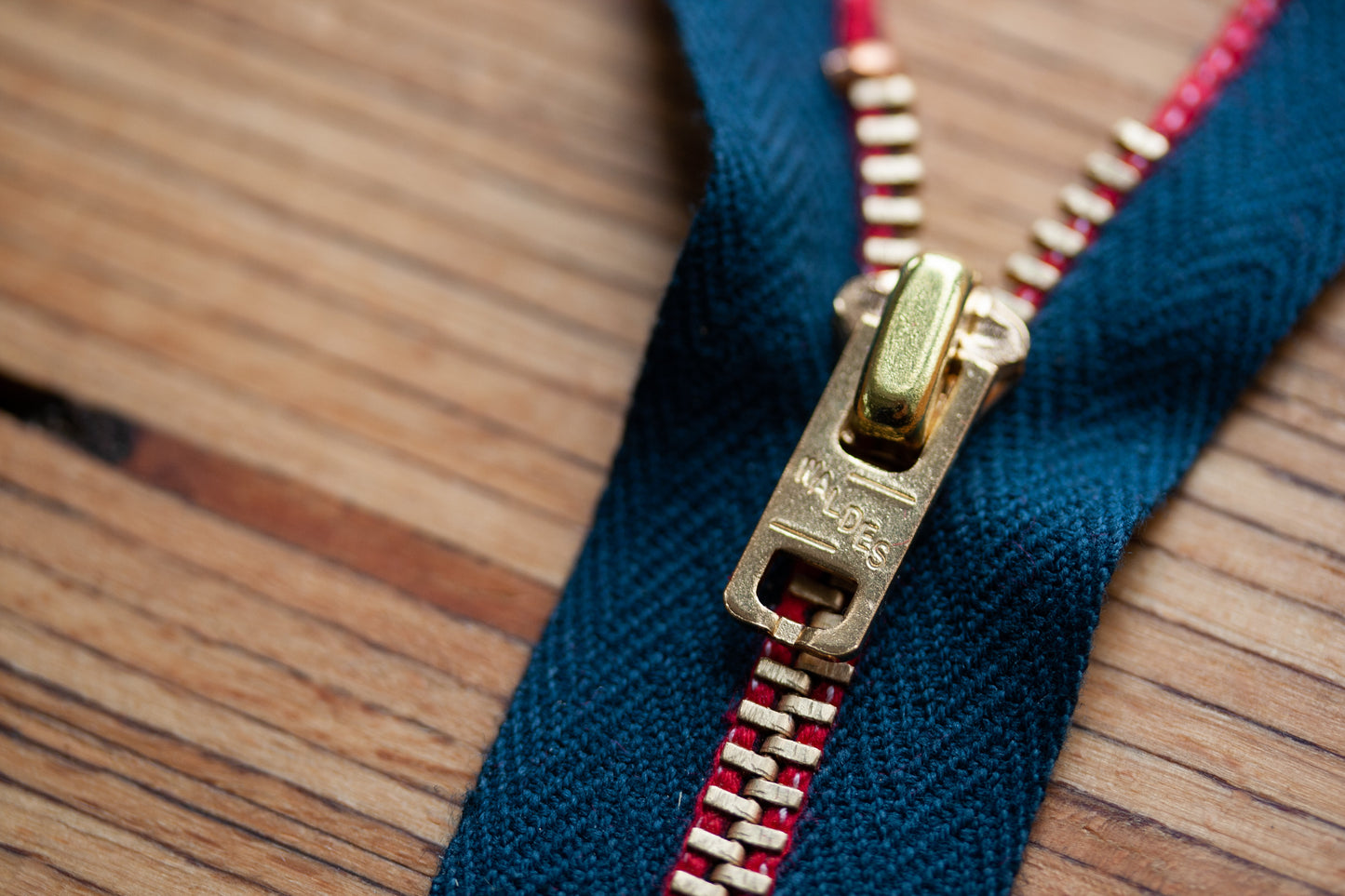 Z-001 Jeans-Reißverschluss aus Messing – alternative Schieber-Ansicht mit Waldes Prägung, rote Webkante auf blauem Band